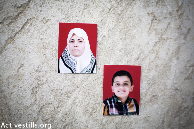 תמונות של ניסראן אחמד (38) ובנה (חוסיין חאלד אחמד (8), מצולמות על הריסות המשפחה בדיר אל-באלאה, 25 מרץ, 2015. (אן פאק / אקטיבטסילס)