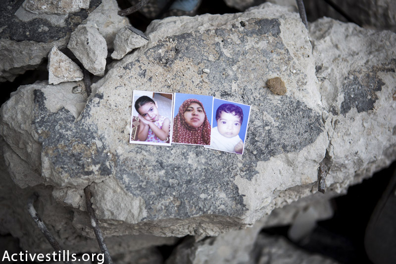 תמונות של אסאייל מוחמד אל-באקרי (4), אמה איבתיסאם איברהים אל-באקרי (38) ואחותה (אסמא (5-חודשים), מצולמות על הריסות בית המשפחה, במחנה הפליטים אל-שאטי, העיר עזה, ספטמבר 14, 2014. הן נהרגו בהפצצת בית המשפחה יחד עם עוד שני קרובים. (אן פאק / אקטיבסטילס)