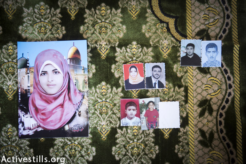 תמונות משפחת אל-לאו מצולמות על שטיח בבית המשפחה, דיר אל-באלה, עזה, ספטמבר 16, 2014. שמונה מחברי המשפחה נהרגו במתקפה ב 20 לאוגוסט 2014. (אן פאק / אקטיבסטילס)