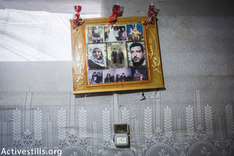 תמונות משפחתו של זאקי וואדאן, מצולמות באוהל זמני בבית ח׳אנון, עזה, פברואר 18, 2015. שמונה מחברי המשפחה, בעיקר נשים וילדים, נהרגו במתקפה על בית המשפחה ב 22 ליולי, 2014. (אן פאק / אקטיבסטילס)
