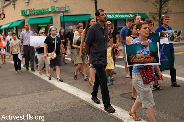 פעילים יהודים ותומכים צועדים לציון ולהנצחת ההתקפה הישראלית בעזה בקיץ 2014, שנה אחרי בברוקלין, ארה״ב, 26 ביולי 2014. הצועדים נשאו תמונות שצולמו ע״י צלמי אקטיבסטילס בעזה במהלך התקפה ולאחריה. (טס שפלן/אקטיבסטילס)
