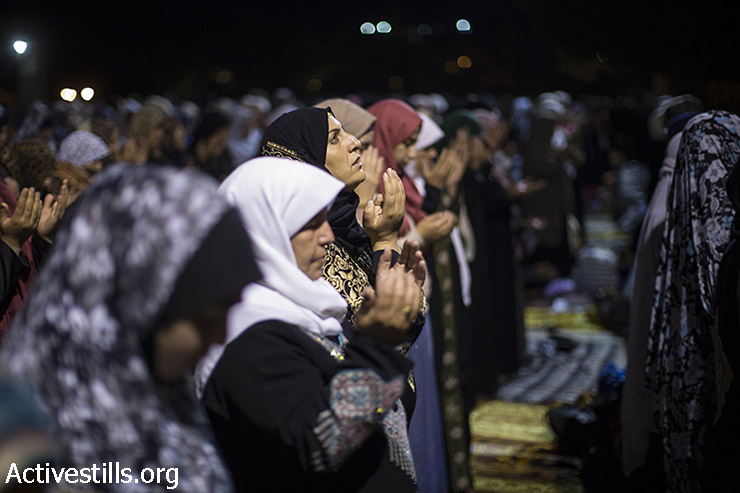 נשים פלסטיניות מתפללות במהלך ליילת אל-קאדר, מחוץ לכיפת הסלע במתחם מסגד אל-אקצא בעיר העתיקה בירושלים, 13 ביולי, 2015.   (פאיז אבו רמלה/אקטיבסטילס)