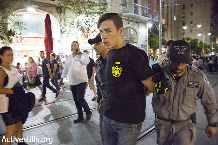פעיל ימין עם חולצת להבה נעצר במהלך הפגנת זעם של פעילות להטב״ק בעקבות פיגוע הדקירה במצעד הגאווה בירושלים, שעות ספורות לפני כן, 30 ביולי  2015. (קרן מנור/אקטיבסטילס)