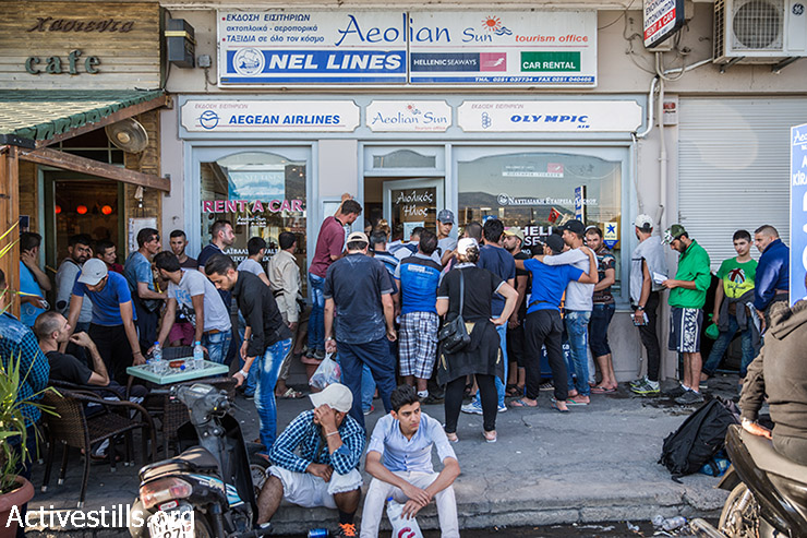 פליטים מחכים בתור לקנות כרטיס למעבורת שתיקח אותם מנמל מיטילנה לאתונה, לסבוס , יוון, 12 בספטמבר 2015.  (יותם רונן/אקטיבסטילס)