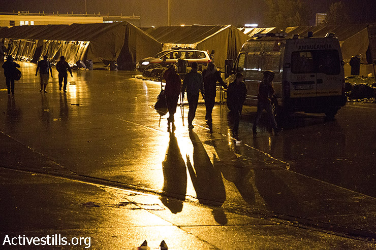פליטים הולכים בגשם במחנה המעבר בגבול אוסטריה, 14 בספומבר 2015. (קרן מנור/אקטיבסטילס)