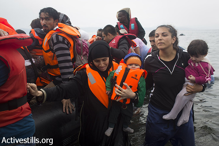 פליטים יורדים מסירת גומי תחת גשם אל חוף אפתלו, ממערב לנמל מיטילנה, באי היווני לסבוס לאחר שחצו את הים האגאי מטורקיה, 23 בספטמבר,2015. (אורן זיו/אקטיבסטילס)