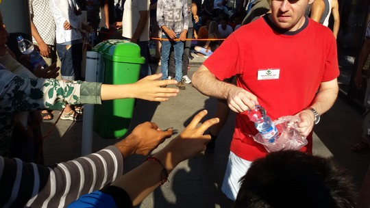 אזרחים מתנדבים מקבוצת "סיוע למהגרים" מחלקים מים ומזון למבקשי המקלט השוהים בתחנה המרכזית בבודפשט (שחר שוהם)