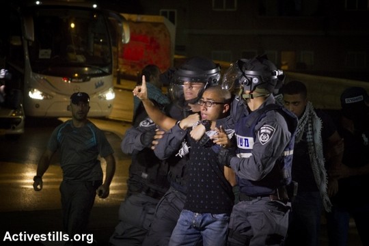שוטרים עוצרים מפגין במהלך הפגנה בנצרת, 8 באוקטובר 2015 (פאיז אבו-רמלה)