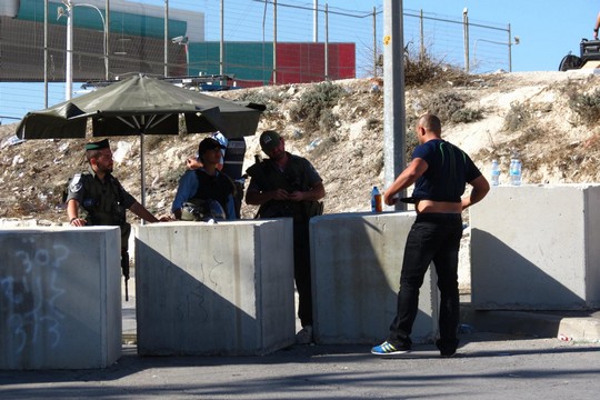 שוטירם במחסום עושים חיפוש על תושב עיסאוויה (צילום: תעאיוש)