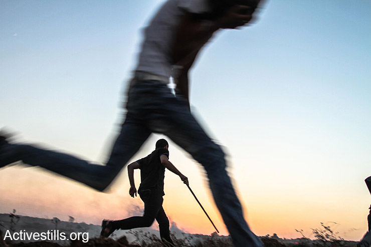 פלסטינים רצים מגז מדמיע במהלך עימותים במחנה הפליטים בוריג׳, רצועת עזה, 18 אוקטובר, 2015. (אקטיבסטילס)