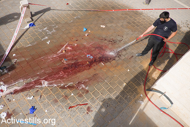 שוטרים מנקים דם לאחר מה שתואר על ידי המשטרה כאירוע דקירה בו נורו שני פלסטינים, בית שמש, 22 אוקטובר, 2015. (אקטיבסטילס)