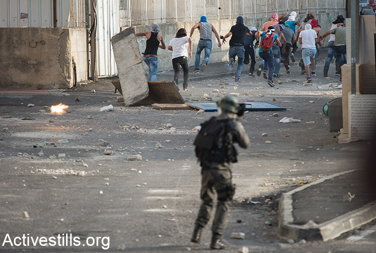 נערים פלסטינים רצים מירי של כוחות שיטור ישראליים במהלך עימותים בשועפט, מזרח ירושלים, 5 אוקטובר, 2015. 