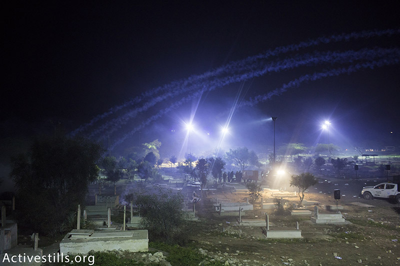 כוחות משטרה יורים גז מדמיע ופצצות תאורה במהלך הלוויתו של סמי אל-ג׳אר, בית הקברות ברהט, ישראל, ינואר 18, 2015. אורן זיו / אקטיבסטילס