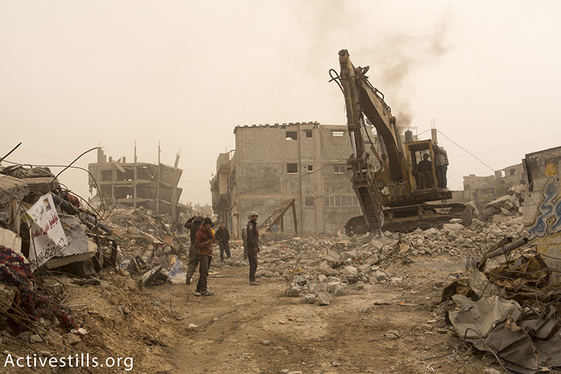 בולדוזר מנקה הריסות בתים בשכונת שג׳עיה, מזרח רצועת עזה, 11 פברואר, 2015. אן פאק / אקטיבסטילס