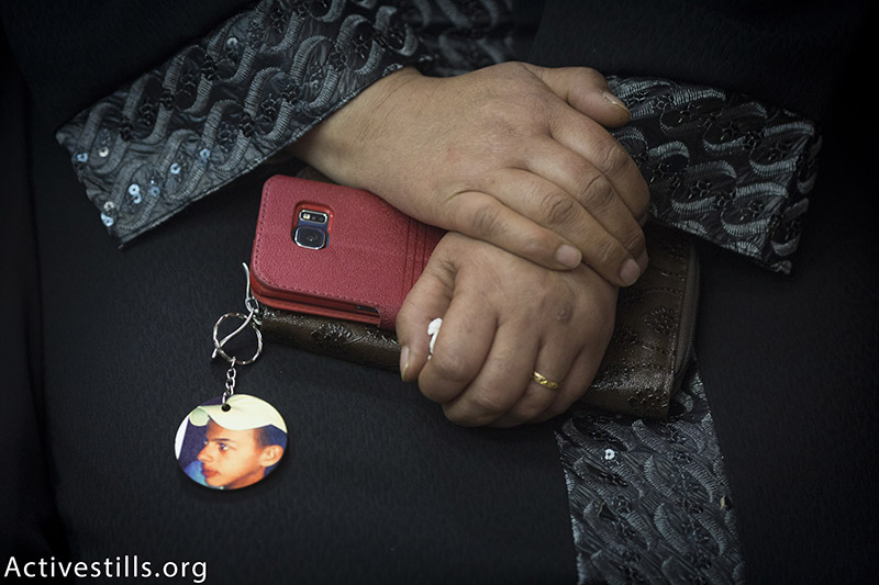 סוהא, אמו של הנער מוח׳מד אבו-ח׳דאר, מחזיקה את תמונתו, במהלך טקס לציון שנה להירצחו בשריפה על ידי יהודים, מזרח ירושלים, 30 נובמבר, 2015. אורן זיו / אקטיבסטילס