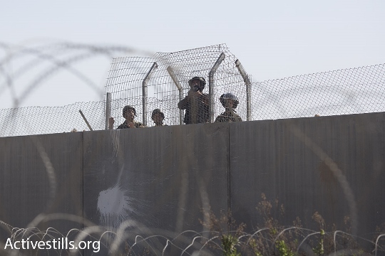 חיילים ממוגנים על החומה בכפר בלעין (אורן זיו / אקטיבסטילס)
