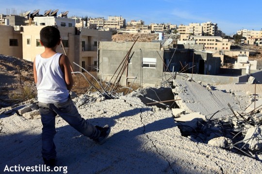 ילד פלסטיני עומד על בית שנהרס על ידי הרשויות בירושלים המזרחית (אן פאק/אקטיבסטילס)