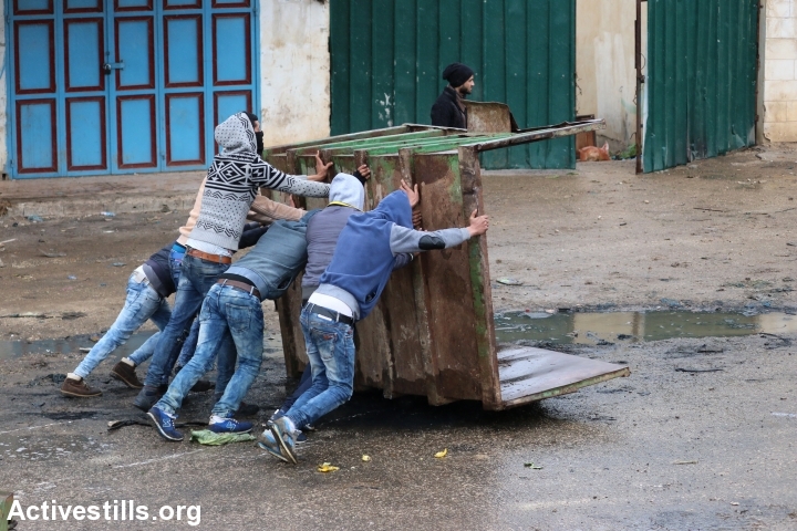 צעירים פלסטינים תופסים מחסה בזמן עימות על חיילים בקבטיה, 6 בפברואר 2016 (אחמד אל-באז/אקטיבסטילס)