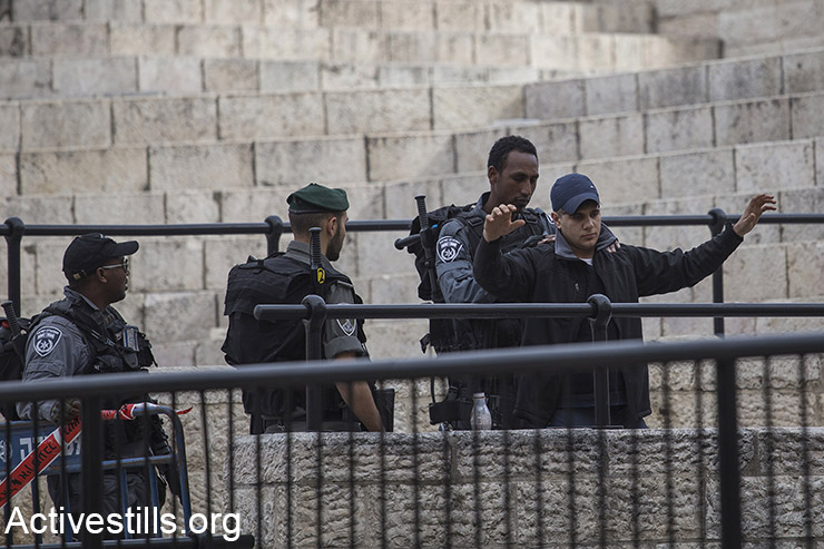 שוטרי משמר הגבול מבצעים בדיקה גופנית לצעיר פלסטיני בשער שכם של העיר העתיקה בירושלים, 18 בפברואר 2016. (פאיז אבו רמלה / אקטיבסטילס)