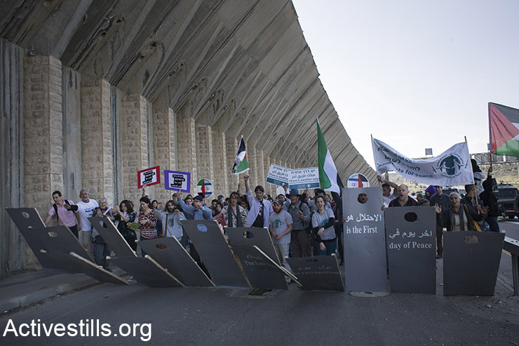 פעילים מחזיקים מייצג המדמה את חומת הפרדה במהלך הפגנה נגד הכיבוש על כביש הראשי המחבר בין ירושלים לחברון, בית ג'אלה, הגדה מערבית, 5 בפברואר, 2016. (אורן זיו / אקטיבסטילס)