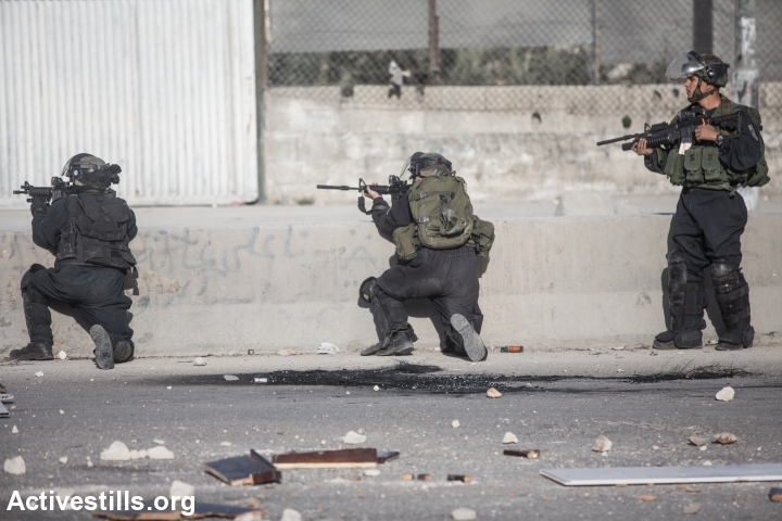 שוטרים יורים לעבר פלסטינים במחסום קלנדיה, 2014 (יותם רונן / אקטיבסטילס)