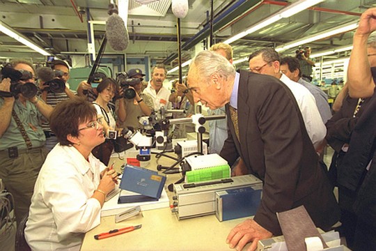 ראש הממשלה שמעון פרס משוחח עם עובדת מפעל האלקטרוניקה "דייל" שבדימונה במהלך סיור שערך בעיר. 1996. (צילום: אבי אוחיון/לע"מ)