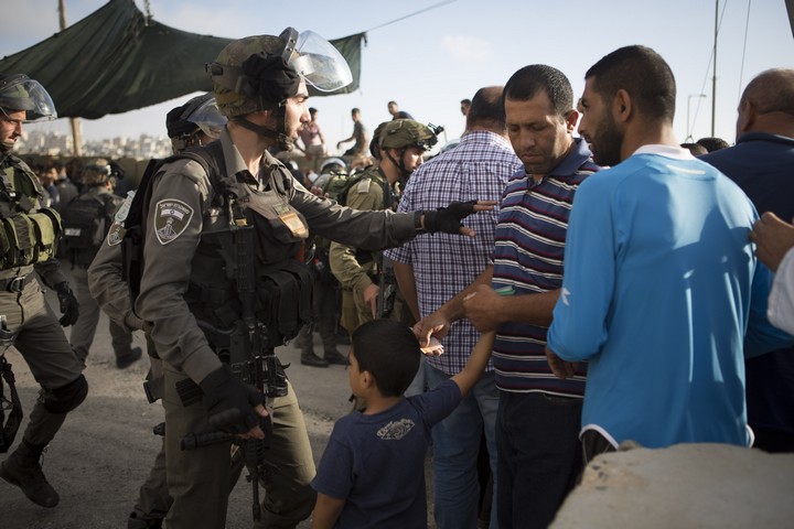 שוטר מג"ב הודף פלסטינים במחסום קלנדיה, יולי 2016 (אורן זיו / אקטיבסטילס)
