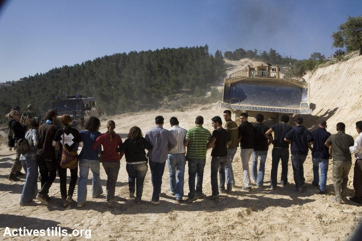 פעילים ישראלים ופלסטינים במאבק משותף, חוסמים דחפורים שעובדים על הקמת גדר ההפרדה באזור בית ג'אלה, 2010 (קרן מנור / אקטיבסטילס)
