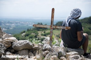 צעיר מביט אל אזור הכפר הפלסטיני המגורש, איקרית, צפון ישראל, ה-21 לאפריל, 2014. (ריאן רודריק ביילר/אקטיבסטילס)