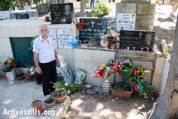 האנה נאסר, עומד ליד קבר משפחתו בבית הקברות של הכפר הפלסטיני המגורש איקרית, צפון ישראל, ה-21 לאפריל, 2014. (ריאן רודריק ביילר/אקטיבסטילס)