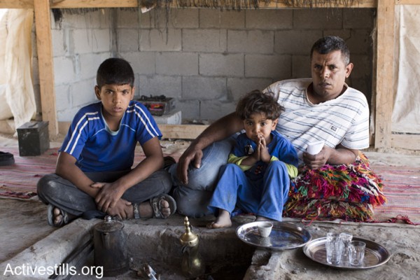 עיאד עדיסאן ושניים מילדיו יושבים במאהל המשפחתי שעות ספורות לאחר 'ביקור' פקחי משרד הפנים והשוטרים (אקטיבסטילס)