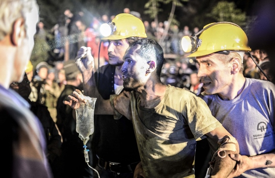 כורה שחולץ מהמכרה נתמך בידי חבריו AFP PHOTO/BULENT KILIC
