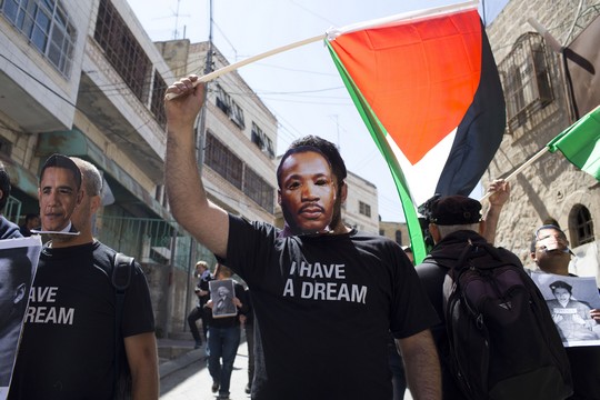 צעירים נגד התנחלויות ופעילים נוספים עוטים מסכות של מרטין לותר קינג ושל ברק אובמה בהפגנה בחברון בזמן ביקורו של הנשיא האמריקאי בישראל (צילום: אקטיבסטילס)