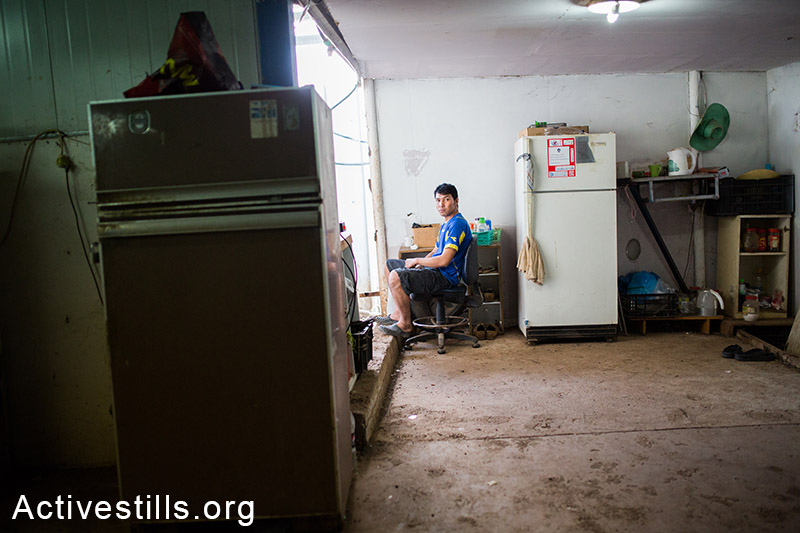 מושב פרזון, נובמבר 2013. עובד תיאלנדי יושב במגוריו. (יותם רונן/אקטיבסטילס)