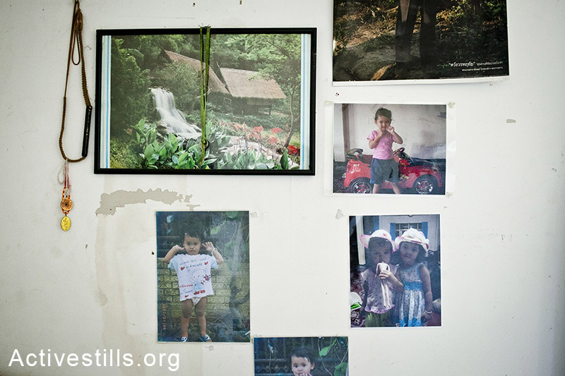 כפר ורבורג, אוגוסט 2013. תמונות משפחה תלויות בחדרו של עובד תאילנדי.  (שירז גרינבאום/אקטיבסטילס)