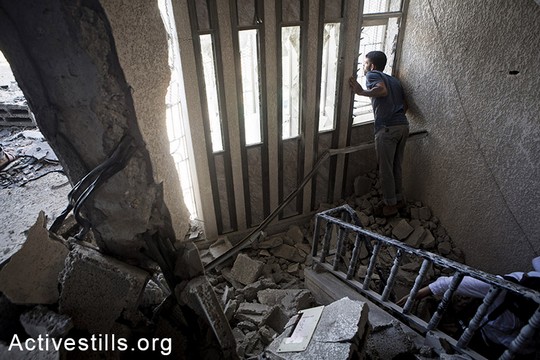 תושבי הכפר עבאסן, מזרחית לח'אן יונס, אומדים את הנזק שנגרם לבתיהם. 26 ביולי, 2014. (אן פאק / אקטיבסטילס)
