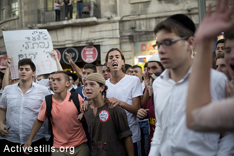 פעילי ימין קוראים קריאות גנאי אל עוברי אורח פלסטינים במהלך  מהומות בזמן הלווית שלושת החטופים, ירושלים, ה-1 ליולי, 2014. (טלי מאיר/אקטיבסטילס)