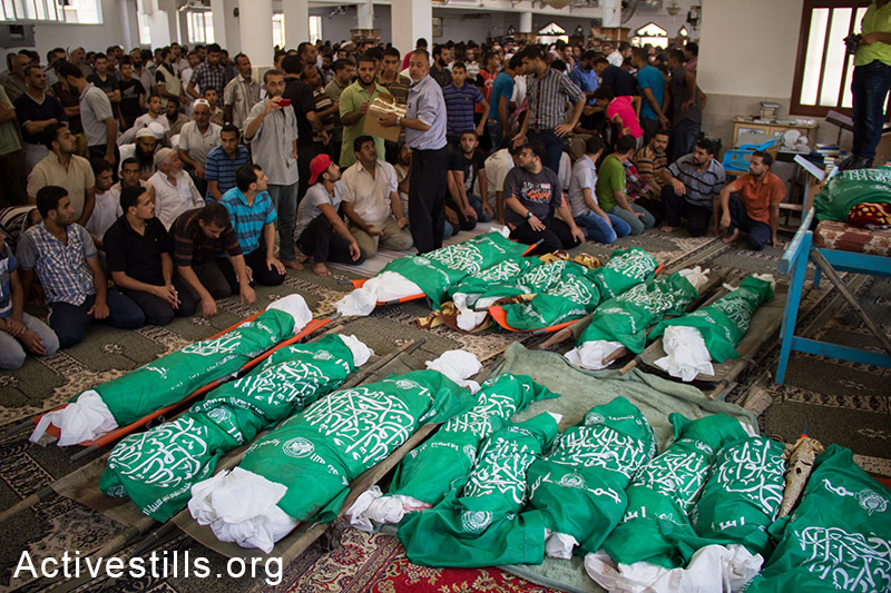 26 גופותיהם של משפחת אבו-ג׳אמע שנהרגה בהפצצות הצבא מונחות לפני הלוויתן. עזה, ה-21 ליולי, 2014. (באסל יאזורי/אקטיבסטילס)