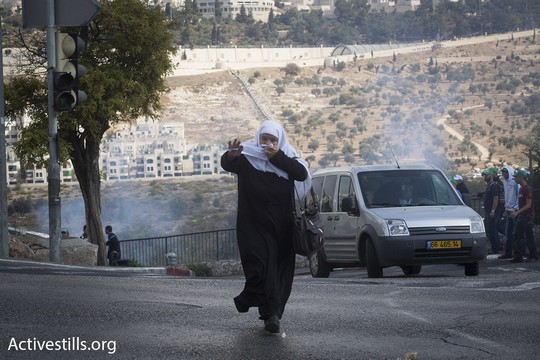 אשה בורחת מרימון הלם בכניסה לשכונת וואדי ג׳וז (אקטיבסטילס)