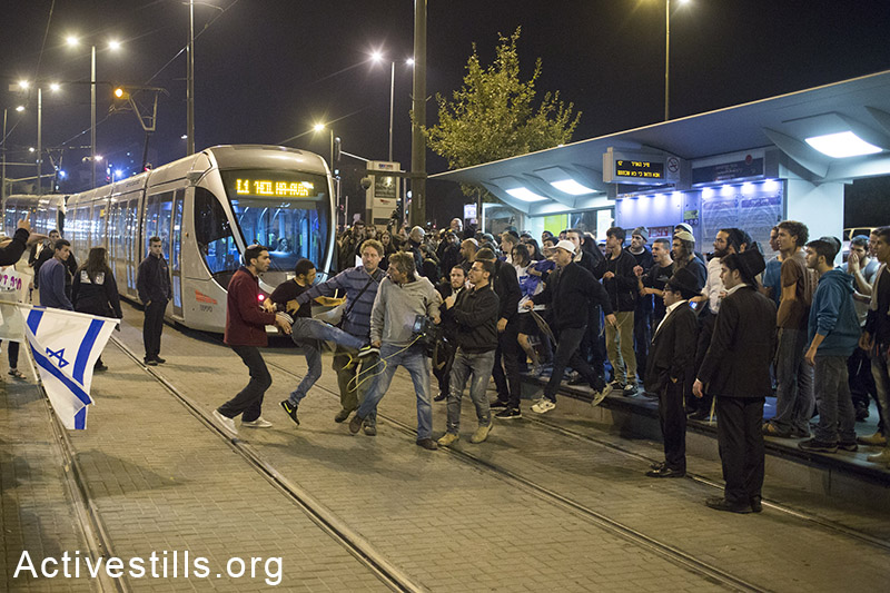 מפגיני ימין מרביצים לעיתונאי במהלך הפגנה תחת הכותרת ׳נקמה׳, באזור תחנת הרכבת הקלה בה התרחש אירוע הדריסה, מזרח ירושלים, 23 אוקטובר, 2014. (אקטיבסטילס)