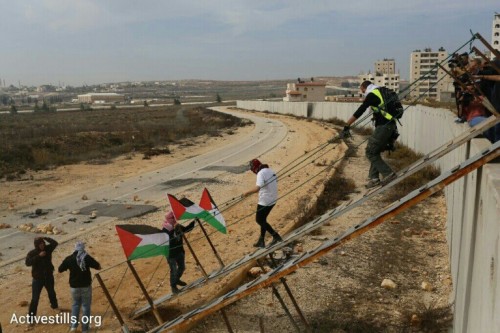 פלסטינים עוברים את הגדר בקלנדיה במחאה על חסימת הגישה למסגד אל אקצא. (צילום אורן זיו/אקטיבסטילס)