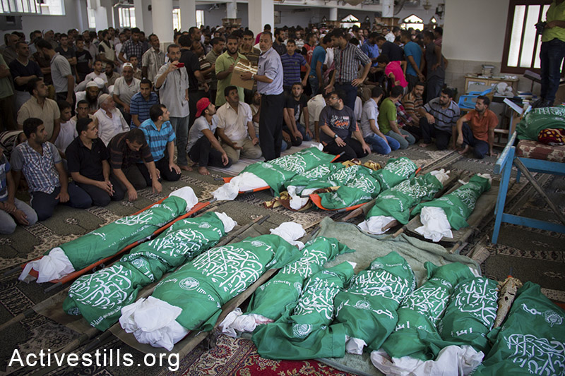 הלוויתם של 26 בני משפחת אבו-ג'מעה שנהרגו יום קודם לכן בעקבות הפצצת הצבא בחאן יונס, רצועת עזה, 21 ביולי, 2014. (באסל יאזורי/אקטיבסטילס)