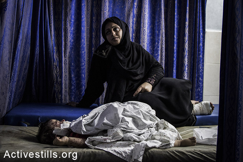 ילד פלסטיני פצוע ואימו בבית החולים שיפא בעזה. 30 ביולי, 2014. (באסל יאזורי/אקטיבסטילס)
