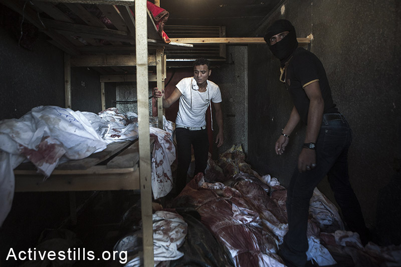 גופות פלסטינים מאופסנות במכולה המשמשת לקרור ירקות, בעקבות חוסר במקום  בבתי החולים בעזה. 3 באוגוסט, 2014. (אן פק/אקטיבסטילס)