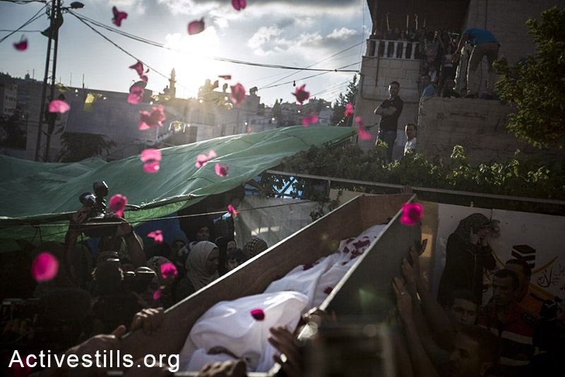 פלסטינים נושאים את גופתו של מוחמד סינוקרות במהלך הלוויתו בשכונת ואדי ג'וז במזרח ירושלים, 8 בספטמבר, 2104. סינוקרות, בן 16, נורה ע״י המשטרה ב-31 באוגוסט ומת מפצעיו. (פיאז אבו רמלה/אקטיבסטילס)
