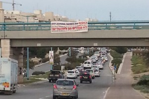 שלט תמיכה בשוטר היורה מתחנת רהט שנתלה על גשר הרכבת בשכונת רמות בבאר שבע. (צילום: חיה נח, פורום דו-קיום בנגב לשוויון אזרחי)