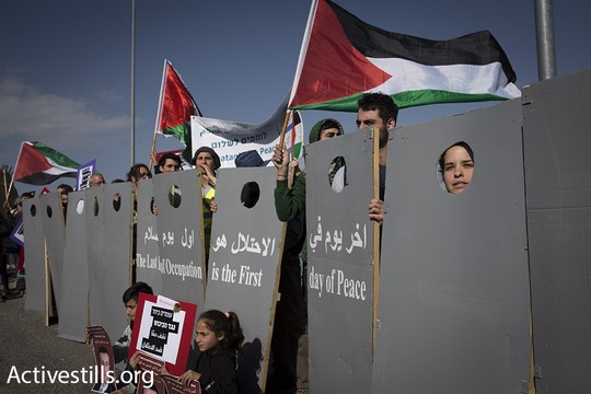 פעילי לוחמים לשלום בהפגנה במחסום המנהרות עם מיצג חומה (אורן זיו / אקטיבסטילס)