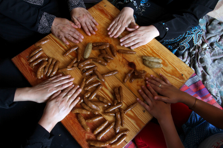 נשים בעזה מכינות קינוח תמרים לקראת עיד אל פיטר (עבד רחמים חטיב / פלאש90)