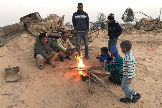 תושבי הכפר ביר הדאג' מתחממים ליד מדורה אחרי הריסות בתים בכפר (רמי יונס)