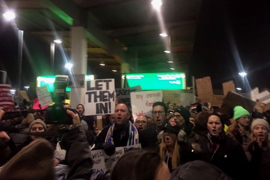 "תנו להם להיכנס", "כל בני האדם חוקיים". מפגינים בשדה התעופה JFK בניו יורק. (צילום: אמה לואיס/Just Vision)